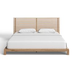 a bed with white sheets and wooden headboard