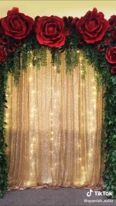 red roses and greenery decorate the backdrop for a wedding or special event with gold sequins