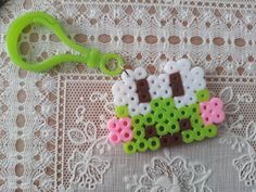 a pair of scissors are sitting on a lace doily with some beads in the shape of sheeps