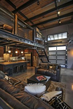 a living room filled with lots of furniture and a loft type structure above the couches