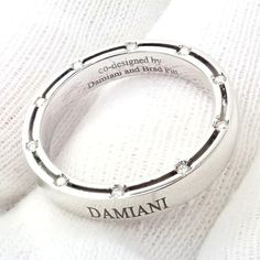 Authentic Damiani Brad Pitt 18k White Gold 20 Diamond 4mm Band Ring Sz 8.25  Retail Price: $2,850  Metal: 18k White Gold  Measurements:  Weight: 6.4 grams  Width: 4mm  Size: 8.25  Stones: 20x round old European cut diamond E-G color, VS-SI clarity total weight approx. .10ct  Hallmarks: Damiani co-designed Damiani and Brad Pitt 750 Made in Italy  Dimensions reference the ring size and are not specific to the ring itself. Luxury Engraved Ring For Anniversary, Designer White Gold Promise Ring, Designer Rings With Polished Finish For Anniversary, Luxury Engraved Ring With Diamond Cut For Formal Occasions, Luxury Engraved White Gold Diamond Ring, Luxury Sterling Silver Engraved Ring With Brilliant Cut, Luxury Engraved Diamond Ring With Round Band, Luxury Diamond Engraved Ring For Anniversary, Luxury Engraved Diamond Ring