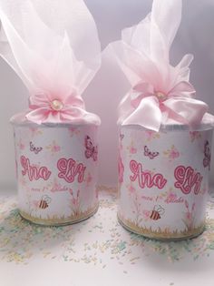 two jars are decorated with pink bows and butterflies