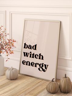 a poster with the words bad witch energy next to two pumpkins and a vase