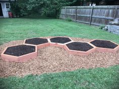 a group of wooden hexagonal planters filled with dirt