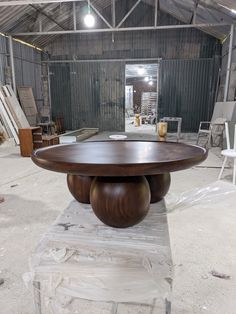 a large wooden table sitting inside of a warehouse