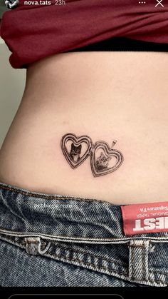 a woman's stomach with two heart tattoos on it