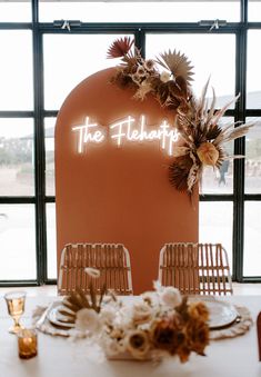 the table is set up with flowers and place settings for an intimate dinner or celebration