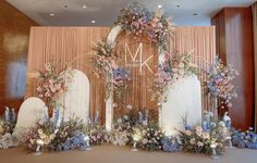 a wedding ceremony setup with flowers and greenery in front of a backdrop that says kk