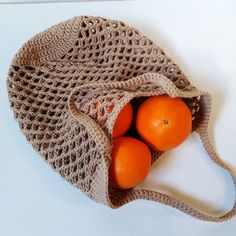 three oranges in a bag on a table