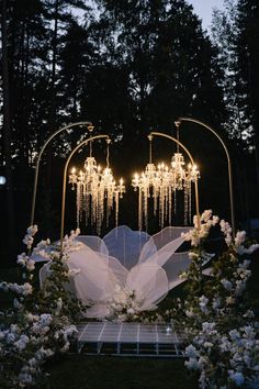 a wedding arch decorated with flowers and chandeliers