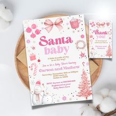 a pink and white baby shower is next to cotton on a plate with the words santa baby