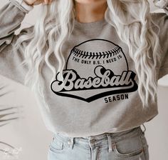 a woman with long white hair wearing a baseball vibes sweatshirt and jeans, holding her hands to her ears