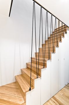 a set of wooden stairs with black string running down the bottom and handrails