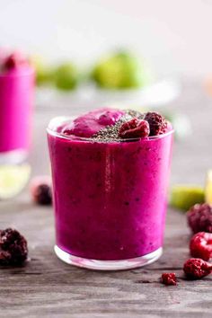 a smoothie with raspberries and limes on the side