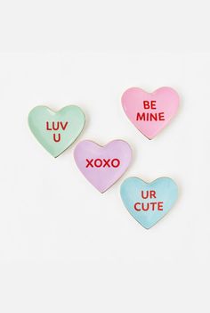 three conversation hearts with the words be mine and xoxo in different colors on them