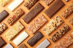 many different types of bars are arranged in a grid on the wall, including one with nuts and granola