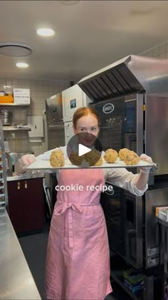 a woman holding a tray with cookies on it