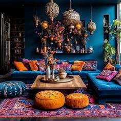 a living room filled with lots of furniture and colorful pillows on top of it's blue walls