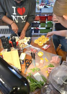 two people are preparing food on a table