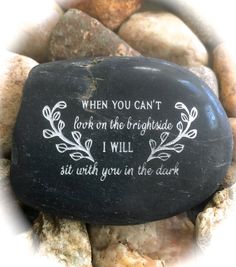 a rock with the words, when you can't look on the brightside i will sit with you in the dark