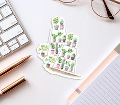 a sticker with potted plants on it next to a keyboard and eyeglasses