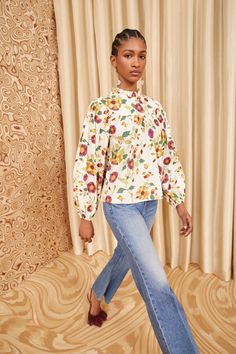 Our Ardith Blouse is alive with romantic tumbling florals inspired by a vintage batik print. A bestselling silhouette, this cream, pink, and orange style features long voluminous sleeves, elegant gathers at the yoke, and is traced with delicate ruffles at the high neckline. It has elastic cuffs and fastens with a butto Nyc Boutiques, White Iris, Orange Style, Batik Print, Long Sleeve Floral Top, Batik Prints, Orange Fashion, Blouse White, Signature Print