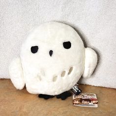 a white stuffed animal sitting on top of a wooden table next to a package of candy