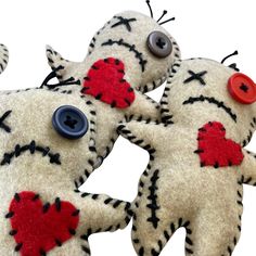 two handmade stuffed animals with buttons on their eyes and hands, one is holding the other