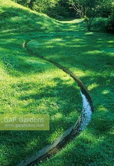 a small stream in the middle of a grassy field