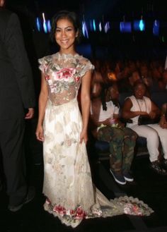 a woman standing in front of a crowd at a fashion show