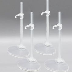 three clear glass candlesticks with white handles