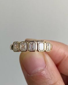 someone is holding an antique ring with five baguettes on each side and three diamonds in the middle