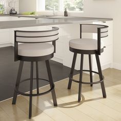 two white stools sitting next to each other in a kitchen with an island counter