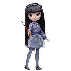 a doll with long black hair holding a wand and wearing a blue dress, standing on a white background