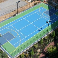 an overhead view of a blue and green tennis court in the middle of a parking lot