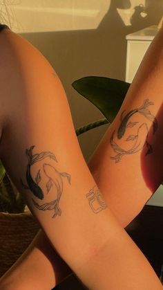 two people with tattoos on their arms