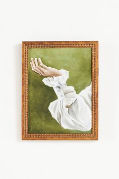 a painting hanging on the wall with a hand reaching out for something to touch it