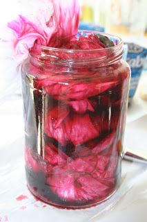 a jar filled with red dye sitting on top of a table