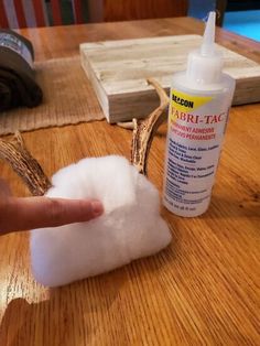 someone is pointing at something that looks like cotton floss and antlers on the table