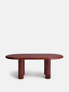 an oval table with two legs and a red top