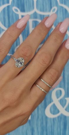 a woman's hand with pink manicured nails and a ring on her finger