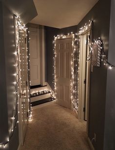 the hallway is decorated with christmas lights and garlands on the door, along with stairs