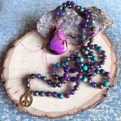 This Hand Knotted 108 Beads Mala Necklace is Made with the Following Gemstones and Crystals: Amethyst, Chrysocolla, Lepidolite, Sea Sediment Jasper, Dragon Vein Agate, Rainbow Hematite, and Finished with a Purple and Fuschia Banded Agate Pendant with Peace Sign and Crescent Moon Charms. Tranquil and protective energy exude from this beautiful Moon Inspired 108 Beads Mala Necklace. Like the moon and its many phases, our hearts, bodies, and minds can draw inspiration from flowing effortlessly with Rainbow Hematite, Crystals Amethyst, Protective Energy, Gemstones And Crystals, Beads Mala, Dragon Vein Agate, 108 Mala Beads, 108 Bead, Beautiful Moon