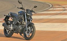 a black motorcycle parked on top of a race track