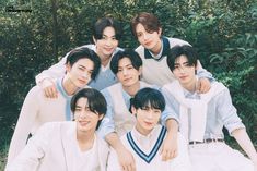 the group of young men are posing for a photo together in front of some trees