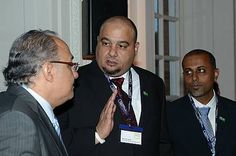 three men in suits talking to each other