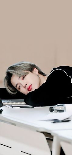 a woman laying on top of a white desk