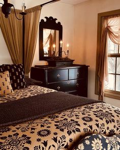 a bedroom with a bed, dresser and mirror on the wall next to two windows