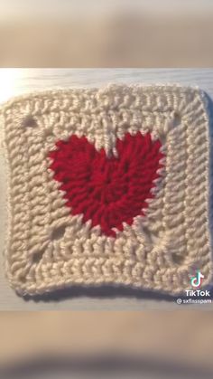 a crocheted square with a red heart on it