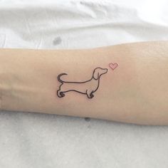 a small black dog tattoo on the arm